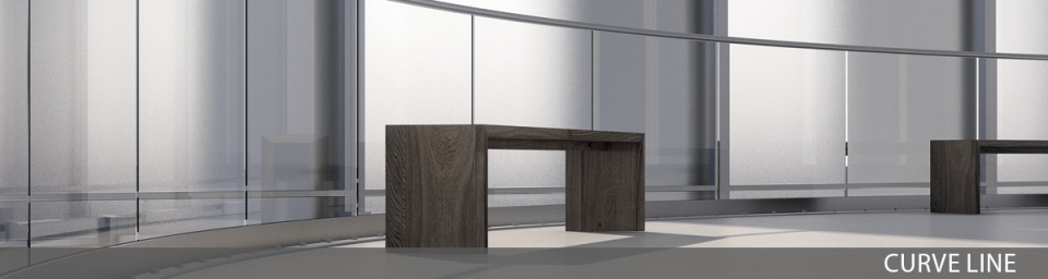 Eine Holzbank steht vor einem modernen gebogenen Ganzglasgeländer.